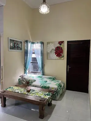 a room with a bed and a bench and a window at 2 Bedroom Guest House Near Jimbaran Beach in Jimbaran