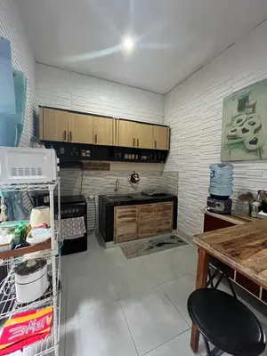 a kitchen with wooden cabinets and a counter top at 2 Bedroom Guest House Near Jimbaran Beach in Jimbaran