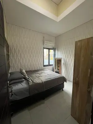 a bedroom with a bed and a wall at 2 Bedroom Guest House Near Jimbaran Beach in Jimbaran