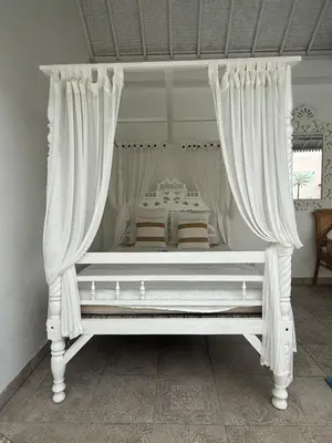 a white canopy bed with curtains in a bedroom at Gypsy Boutique Villa in Seminyak
