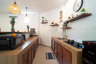 a kitchen with wooden counters and a microwave at Villa WENDY Mertanadi in Seminyak