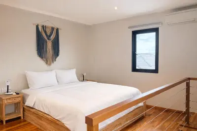a bedroom with a white bed and a window at Glory Rentals in Kuta