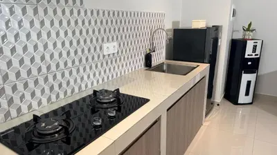 a kitchen with a black stove top oven next to a sink at Glory Rentals in Kuta