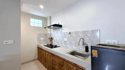 a kitchen with a sink and a blue refrigerator at Glory Rentals in Kuta