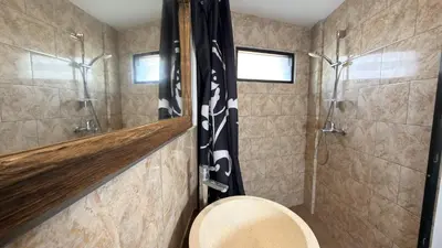 a bathroom with a shower and a toilet in it at Glory Rentals in Kuta