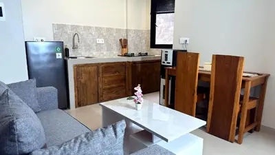 a kitchen with a couch and a table in a room at Glory Rentals in Kuta