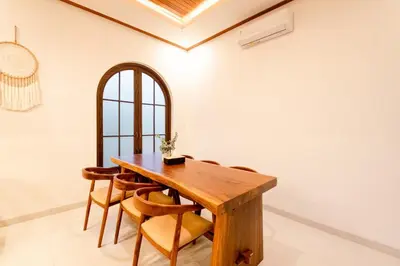 a dining room with a wooden table and chairs at Green Mutiara Jimbaran in Jimbaran
