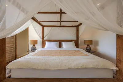 a bedroom with a canopy bed with two lamps at Villa Arta - A Calm, Tropical Villa in Umalas in Canggu