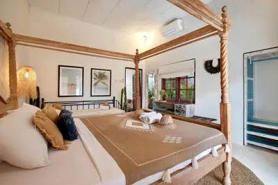 a bedroom with a canopy bed and a fireplace at Seminyak Beach Seagrass Villa 4BR - pool & staff in Seminyak
