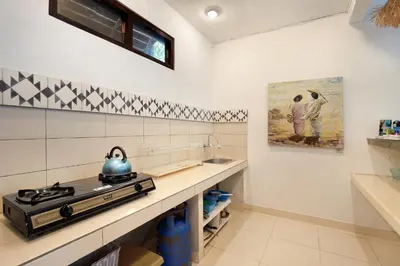 a kitchen with a stove and a sink at Seminyak Beach Seagrass Villa 4BR - pool & staff in Seminyak