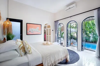 a white bedroom with a bed and a pool at Villa Sobramesa Seminyak with pool, butler & parking in Seminyak