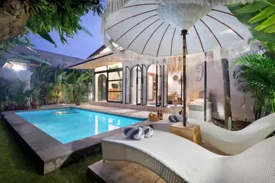 a villa with a swimming pool and an umbrella at Villa Sobramesa Seminyak with pool, butler & parking in Seminyak