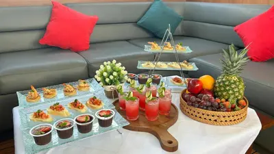 a table with a buffet of food and drinks at La Merry Yacht cruise in Pulau Serangan