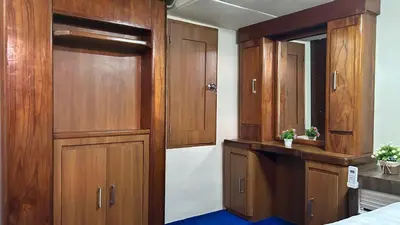 a room with wooden cabinets and a bed and a mirror at La Merry Yacht cruise in Pulau Serangan