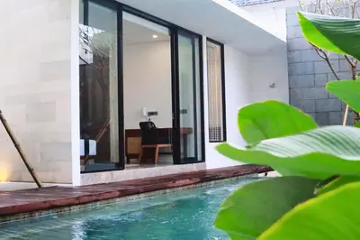 an indoor pool in a house with green plants at Glenda Cozy 3 BR Private Pool Villa in Canggu