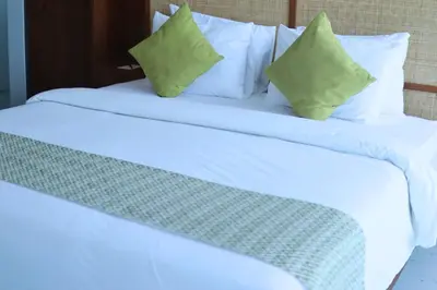 two beds with white sheets and green pillows at Glenda Cozy 3 BR Private Pool Villa in Canggu