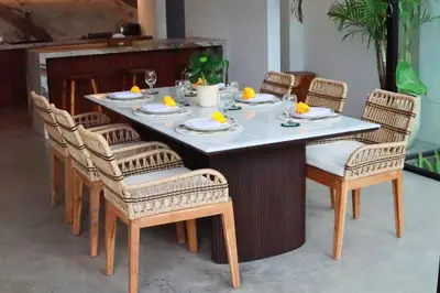 a table with chairs and plates of food on it at Rowena Comfortable 2 BR Private Pool Villa in Canggu
