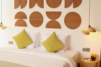a bedroom with a white bed with yellow pillows at Rowena Comfortable 2 BR Private Pool Villa in Canggu