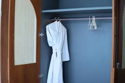 a robe hanging on a rack next to a door at Rowena Comfortable 2 BR Private Pool Villa in Canggu