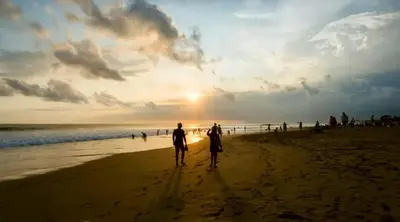 two people walking on the beach at sunset at 3BR Canggu Batu Belig Tropicana Villa - Walk to Beach in Canggu