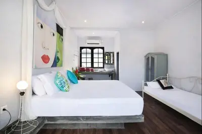a white bedroom with two beds and a kitchen at 3BR Canggu Batu Belig Tropicana Villa - Walk to Beach in Canggu