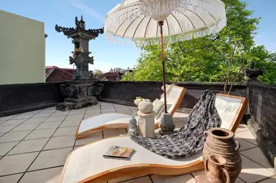 a patio with a table and chairs and an umbrella at WH18 Luxury Loft Villa with Pool & Office in Seminyak
