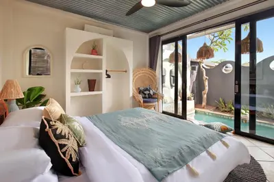 a bedroom with a large bed and a pool at WH18 Luxury Loft Villa with Pool & Office in Seminyak