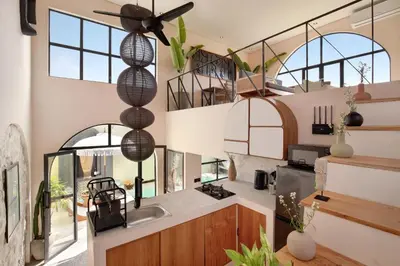 a kitchen with large windows and a ceiling fan at WH18 Luxury Loft Villa with Pool & Office in Seminyak