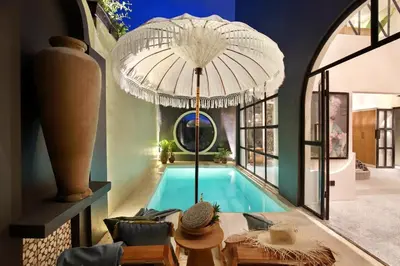 a house with a swimming pool with a large umbrella at WH18 Luxury Loft Villa with Pool & Office in Seminyak