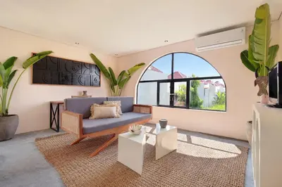 a living room with a blue couch and a large window at WH18 Luxury Loft Villa with Pool & Office in Seminyak