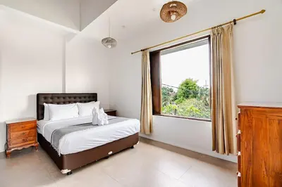 a bedroom with a bed and a large window at iVAVev Isus Lucersfera in Seminyak