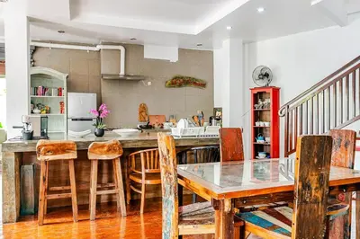 a kitchen with a wooden table and chairs at iVAVev Isus Lucersfera in Seminyak