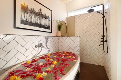 a bathroom with a bath tub covered in flowers at 5 min walk to Seminyak Beach - Architect Designed Luxury Villa - Private Butler & Breakfast in Seminyak