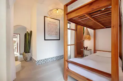 a bedroom with a wooden bed and a mirror at 5BR Luxury Berawa Canggu with Butler in Canggu