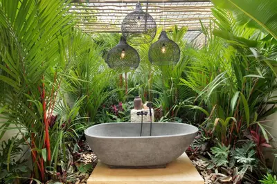 a bath tub in a garden with plants at 5BR Luxury Berawa Canggu with Butler in Canggu
