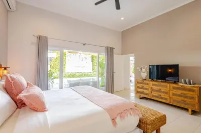 a bedroom with a large bed and a television at 6BR Luxe Pool Villa Seminyak Group Escape in Seminyak