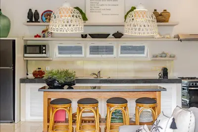 a kitchen with a counter with four bar stools at 6BR Luxe Pool Villa Seminyak Group Escape in Seminyak