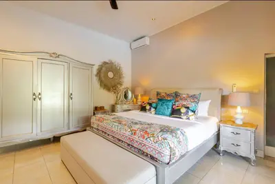 a bedroom with a large white bed and a cabinet at 6BR Luxe Pool Villa Seminyak Group Escape in Seminyak