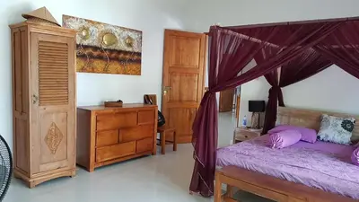 a bedroom with a canopy bed and a wooden dresser at Elegant oasis between Canggu and Seminyak in Kerobokan
