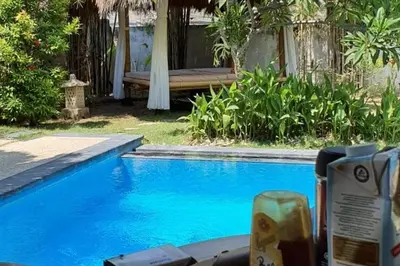 a swimming pool with a bench next to a house at Elegant oasis between Canggu and Seminyak in Kerobokan