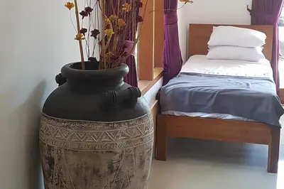 a large black vase with flowers in it next to a bed at Elegant oasis between Canggu and Seminyak in Kerobokan