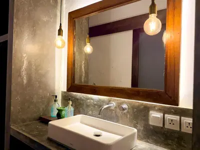 a bathroom with a sink and a mirror and lights at Nauu Villa Umalas in Kerobokan