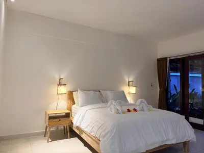 a bedroom with a bed with towels on it at Nauu Villa Umalas in Kerobokan