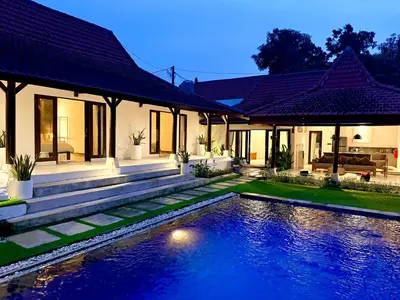 a house with a swimming pool in front of it at Nauu Villa Umalas in Kerobokan