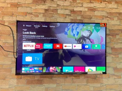a flat screen tv hanging on a brick wall at DBI Hotel - 1 minute to the Beach and 1 second to the Mall in Ngurah Rai International Airport