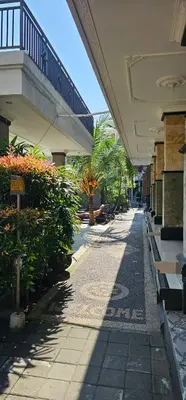 an empty sidewalk in a building with trees and plants at Jepun segara homestay in Ngurah Rai International Airport