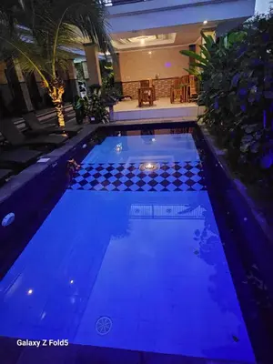 a large swimming pool with blue lighting in a house at Jepun segara homestay in Ngurah Rai International Airport