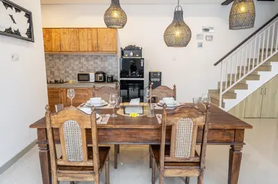 a dining room with a wooden table and chairs at Q LE Villa 2 is 2BR Villa with Private Pool in Seminyak in Seminyak