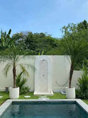 a swimming pool in a yard with two palm trees at Villa Makna Canggu in Canggu