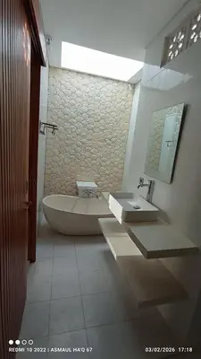 a bathroom with a large tub and a sink at Palm Harmony Villa's Seminyak in Seminyak